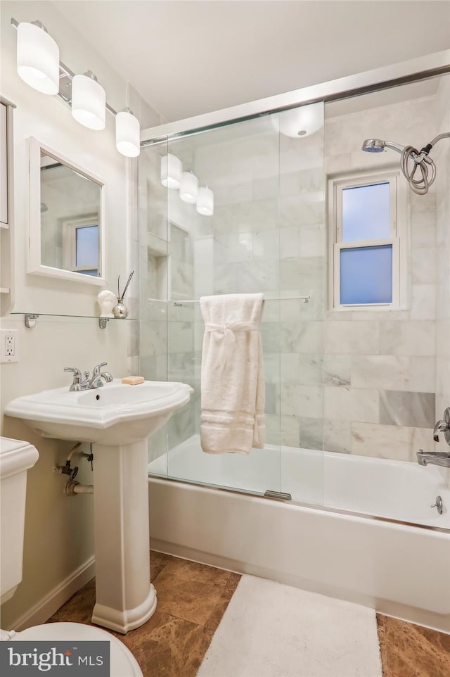 bathroom featuring bath / shower combo with glass door and toilet