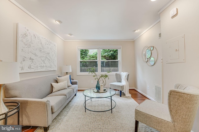 living room featuring light hardwood / wood-style flooring, electric panel, and crown molding