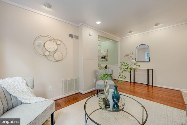 sitting room with crown molding and hardwood / wood-style floors