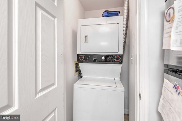 laundry area featuring stacked washer / dryer and water heater