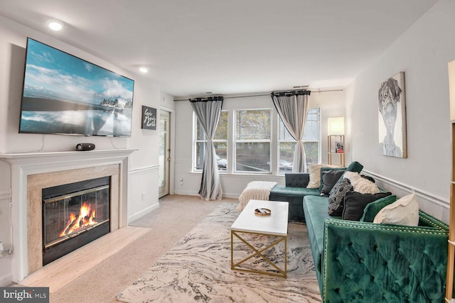 carpeted living room featuring a high end fireplace