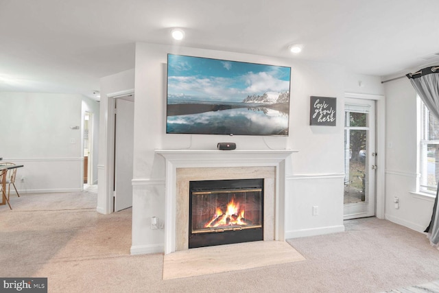 living room with light colored carpet and a premium fireplace