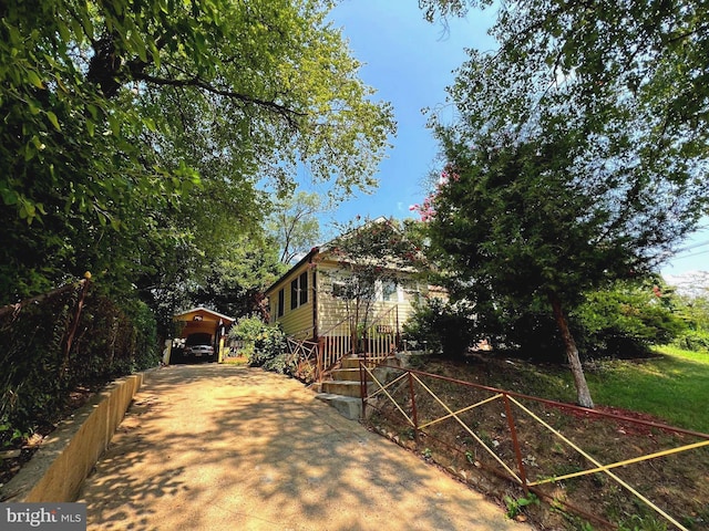 view of front facade featuring concrete driveway and a carport