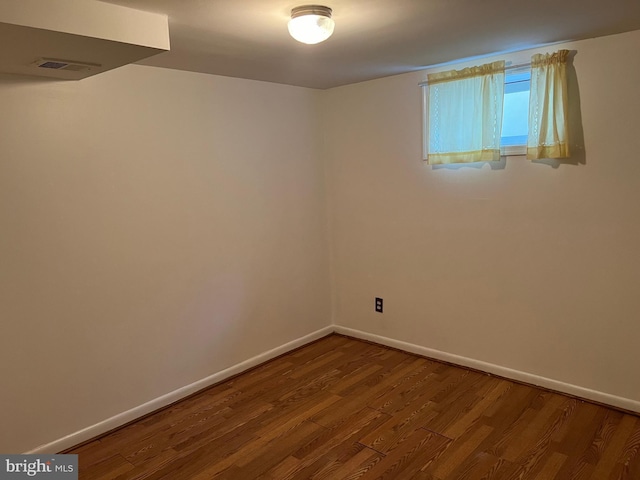 unfurnished room with baseboards and wood finished floors