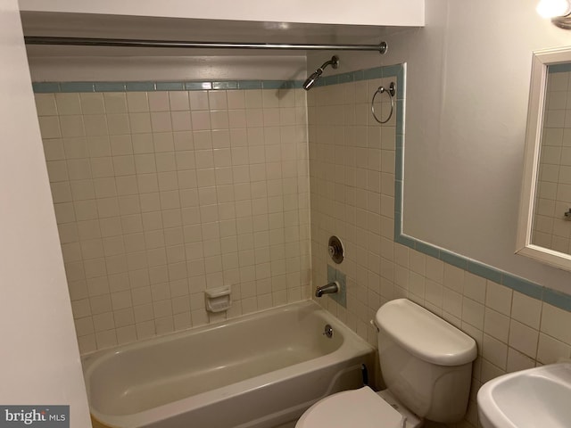 bathroom with  shower combination, toilet, and tile walls