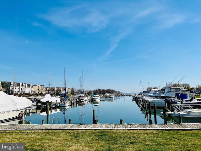 dock area with a lawn and a water view