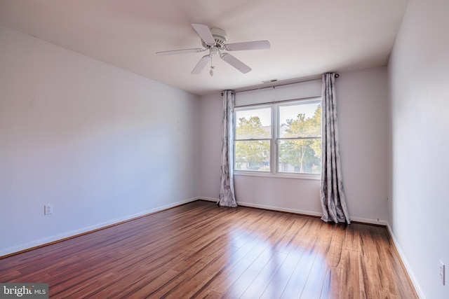 empty room with hardwood / wood-style floors and ceiling fan