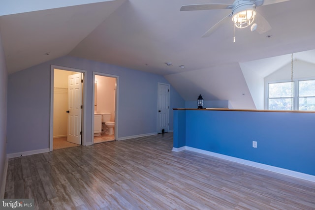 additional living space featuring ceiling fan, vaulted ceiling, and light wood-type flooring