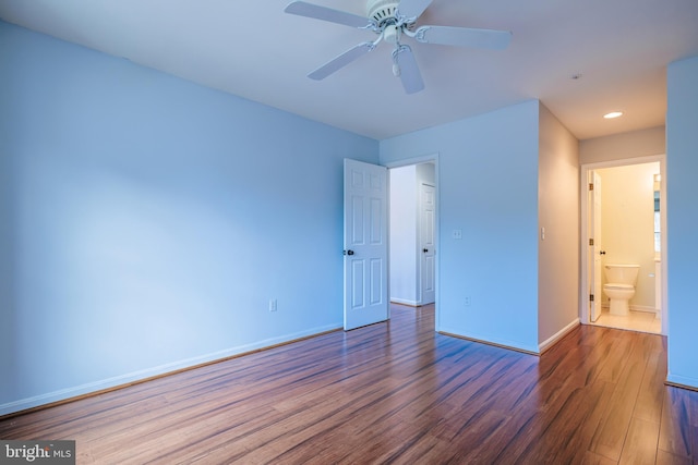 unfurnished bedroom featuring dark hardwood / wood-style floors, ceiling fan, and ensuite bath