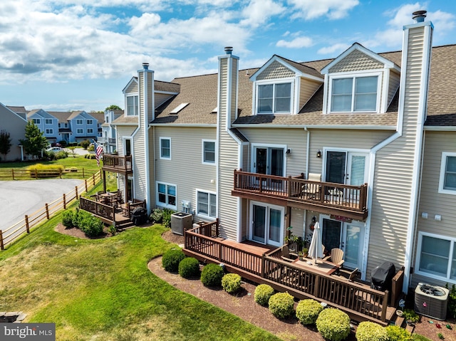 back of property featuring a deck, a lawn, and central air condition unit