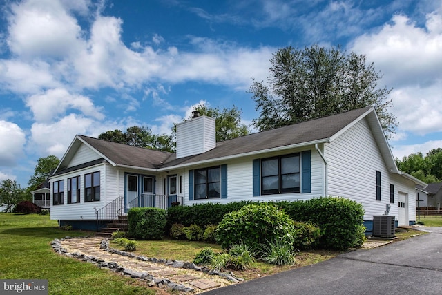 view of front of house with central AC and a front lawn