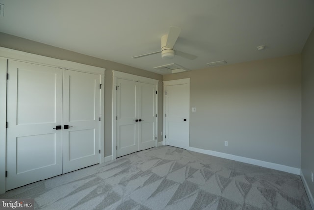 22430 Hummingbird Rd, Ellendale, DE 19941 - unfurnished bedroom with visible vents, two closets, light carpet, baseboards, and a ceiling fan