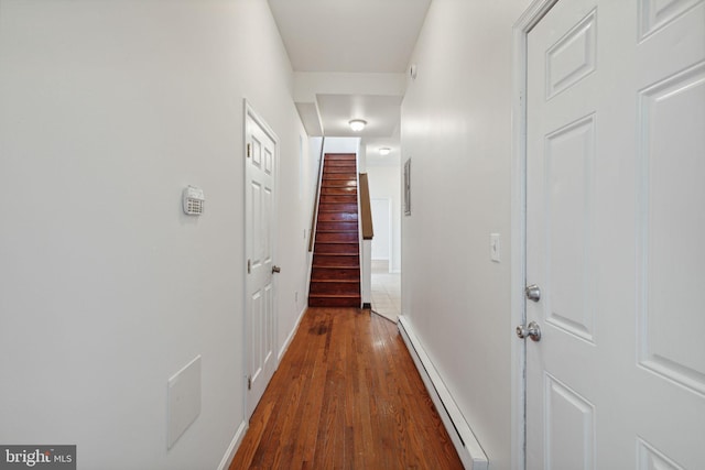 hall with baseboard heating and dark wood-type flooring