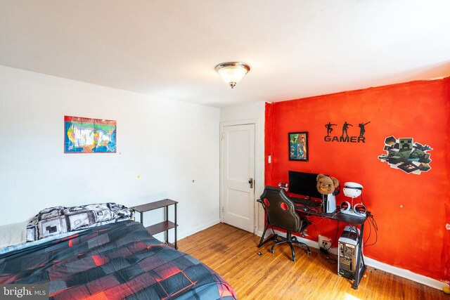 bedroom featuring baseboards and wood finished floors