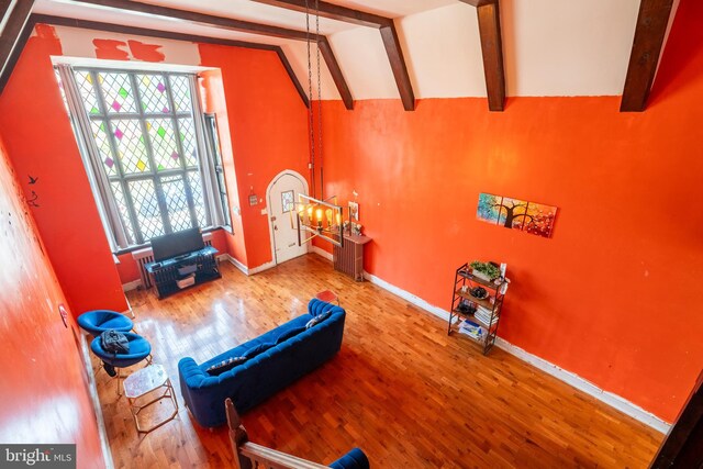 exercise room with lofted ceiling, baseboards, and wood finished floors