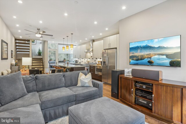 living room with ceiling fan and light hardwood / wood-style flooring