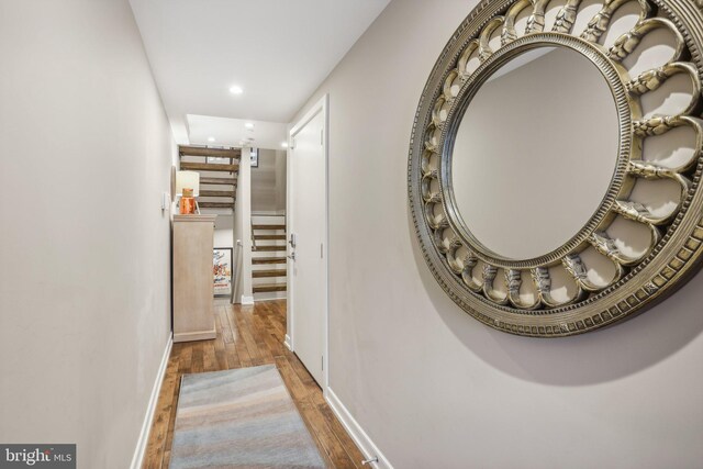 corridor with hardwood / wood-style flooring