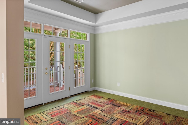 doorway with a raised ceiling and carpet flooring