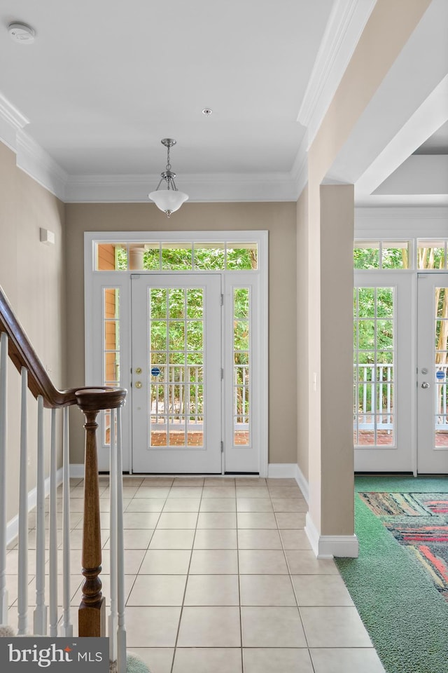 foyer entrance with french doors, light tile patterned flooring, and ornamental molding