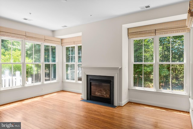 unfurnished living room featuring a healthy amount of sunlight and light hardwood / wood-style flooring