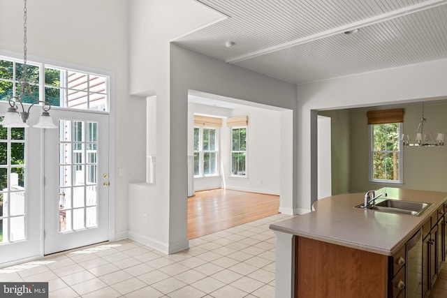 kitchen featuring a notable chandelier, a healthy amount of sunlight, light wood-type flooring, and sink