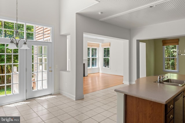 interior space featuring sink, light tile patterned floors, a chandelier, and plenty of natural light