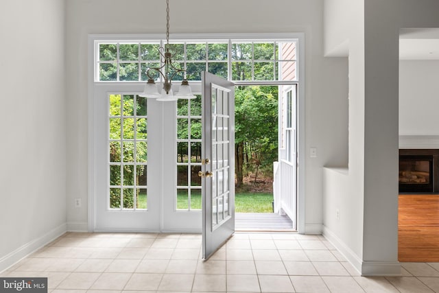 entryway featuring french doors, light tile patterned floors, and a notable chandelier