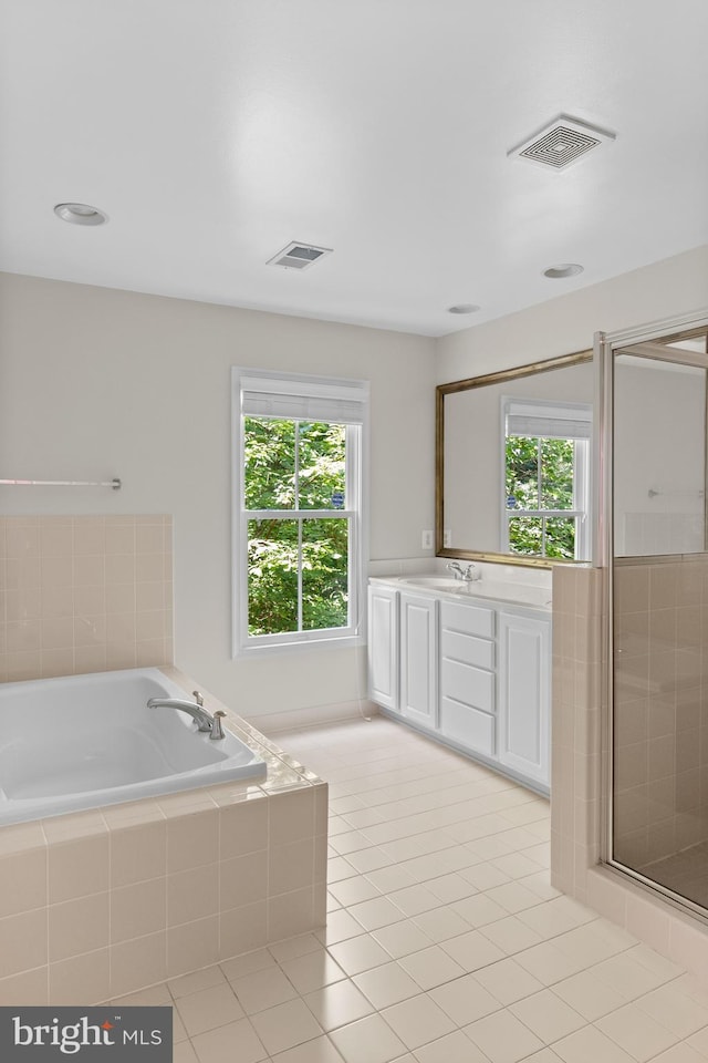 bathroom with tile patterned flooring, vanity, and a healthy amount of sunlight