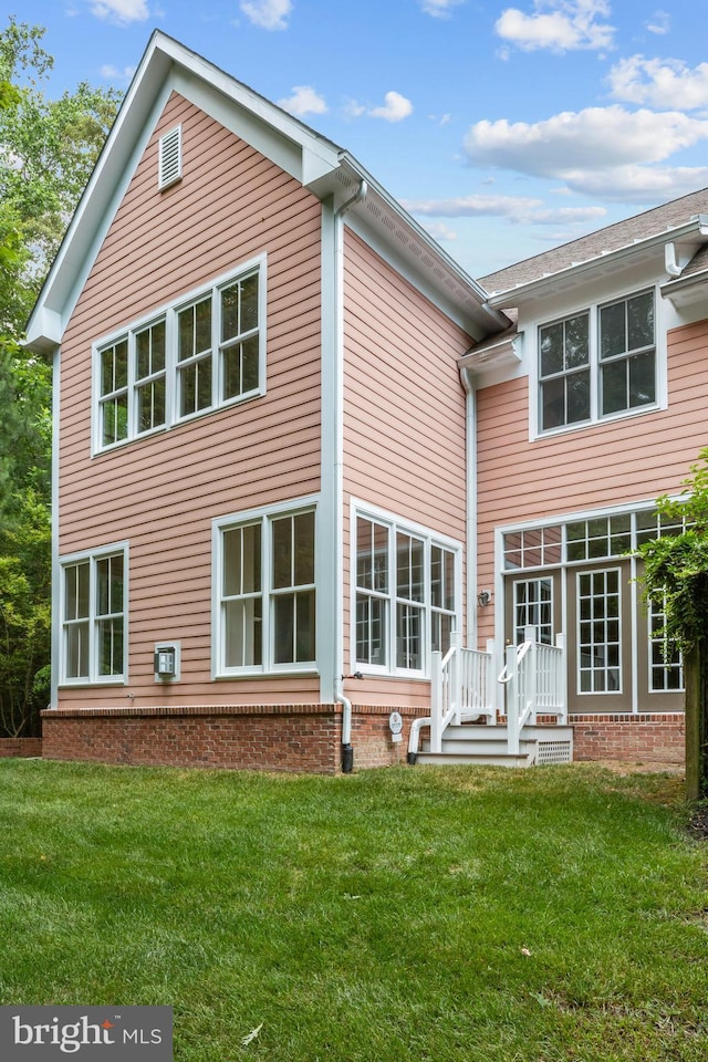 back of house with a lawn