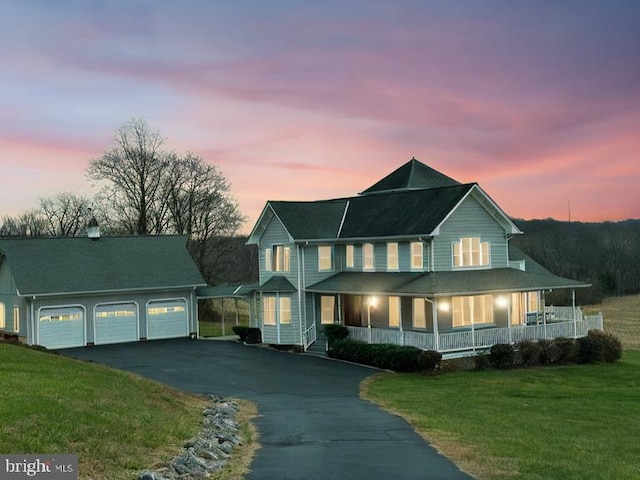 view of front of property featuring a lawn, a porch, and a garage