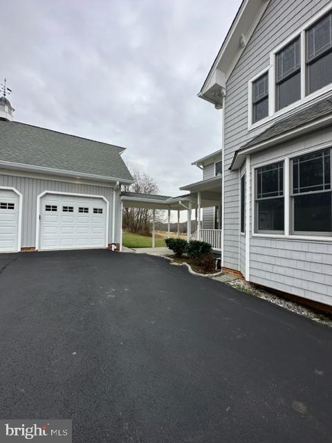 view of side of property with a garage and a porch