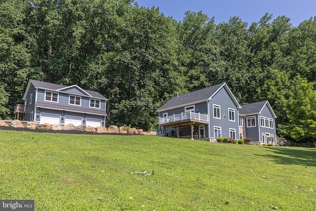 exterior space featuring a lawn, a wooden deck, and a garage