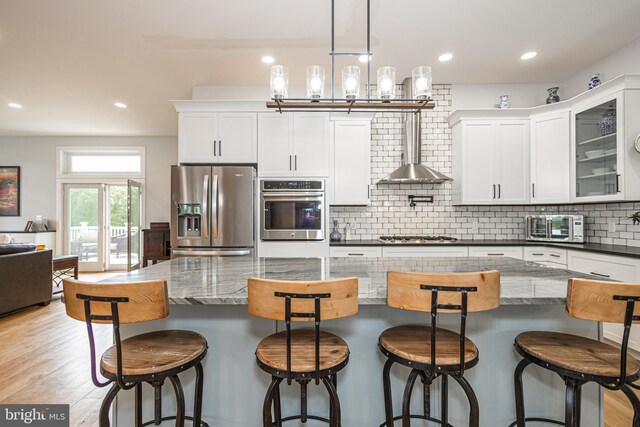 kitchen featuring a kitchen bar, appliances with stainless steel finishes, and white cabinetry