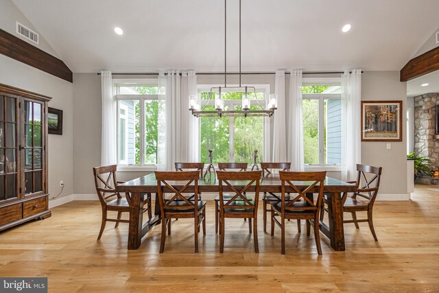 dining room featuring lofted ceiling, a chandelier, and light hardwood / wood-style flooring