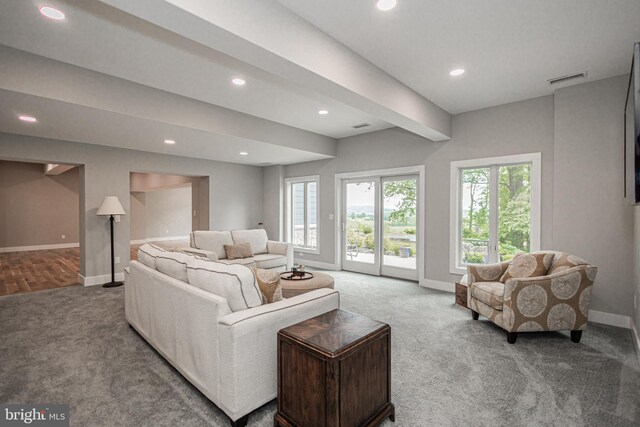 living room with beam ceiling and carpet floors