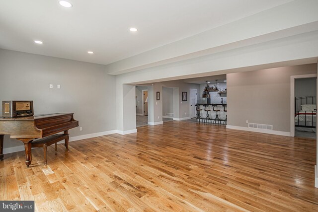 living room featuring light wood-type flooring and bar area