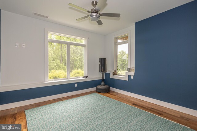 workout area featuring ceiling fan and hardwood / wood-style flooring