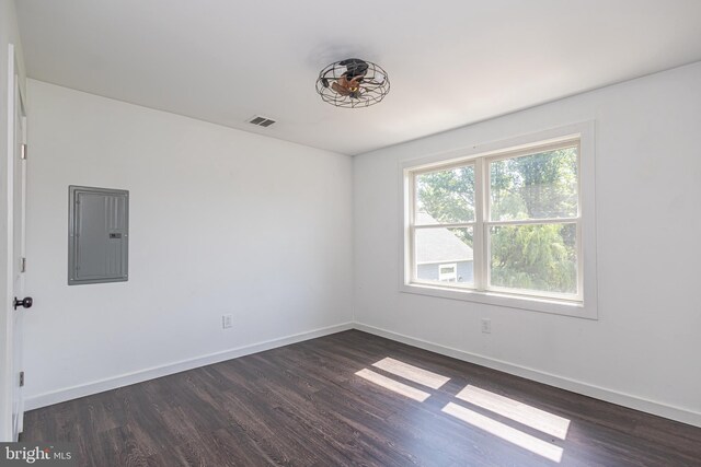 empty room featuring dark hardwood / wood-style flooring and electric panel