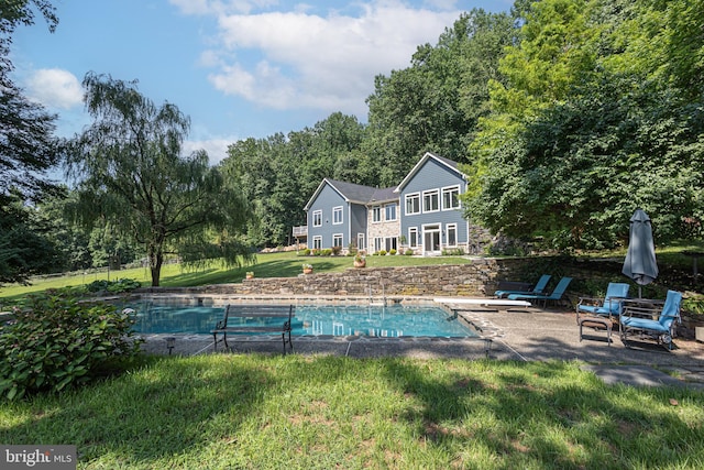 view of swimming pool featuring a lawn and a patio