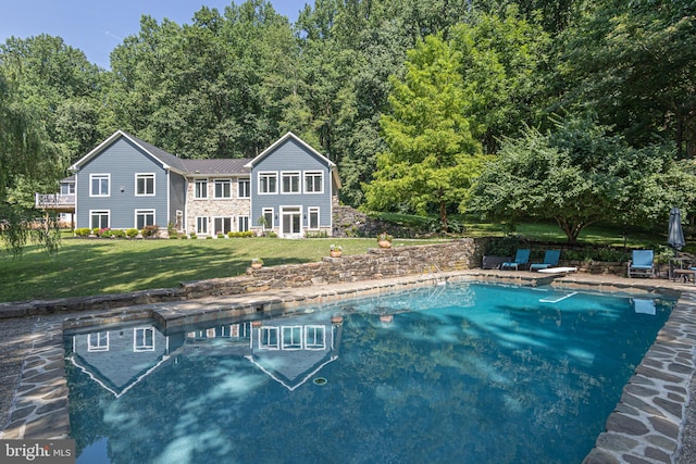 view of pool featuring a lawn and a diving board