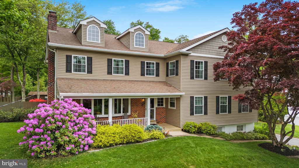 view of front of home with covered porch and a front lawn