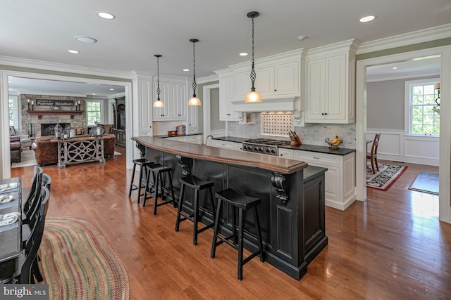 kitchen with range, white cabinets, hardwood / wood-style floors, and a fireplace