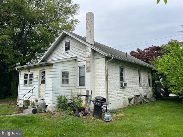 rear view of house featuring a yard