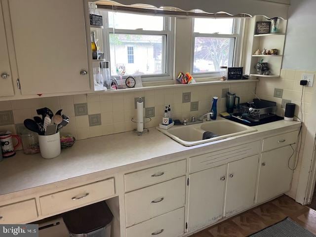 kitchen with sink, backsplash, and white cabinetry