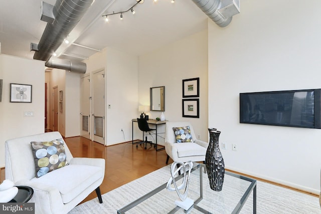 office area with hardwood / wood-style floors and track lighting