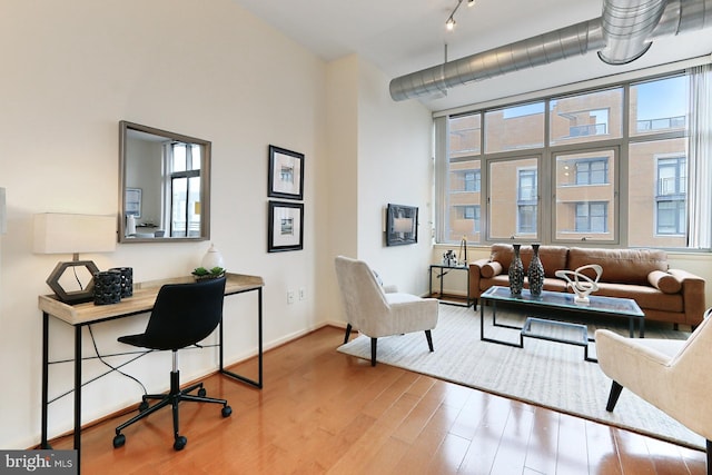 office area featuring a high ceiling, track lighting, and hardwood / wood-style flooring