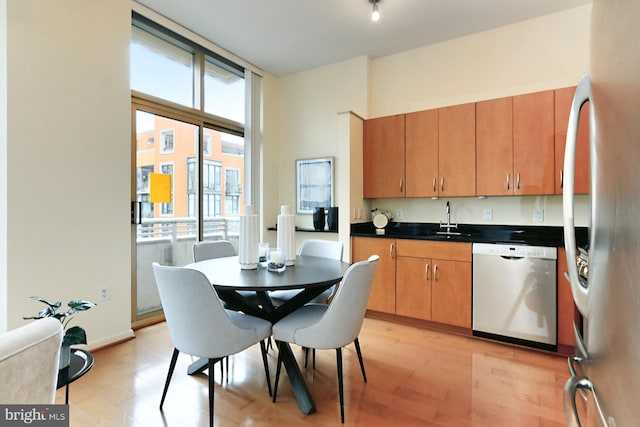 kitchen featuring appliances with stainless steel finishes, sink, and light hardwood / wood-style flooring