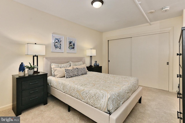 bedroom with light colored carpet and a closet