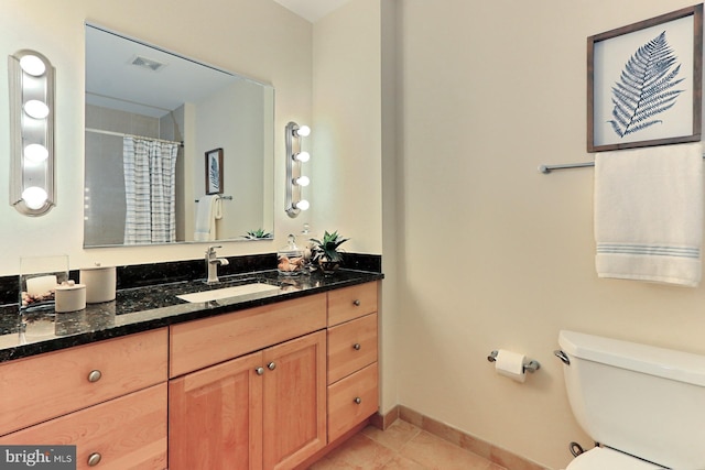 bathroom with tile floors, toilet, and vanity