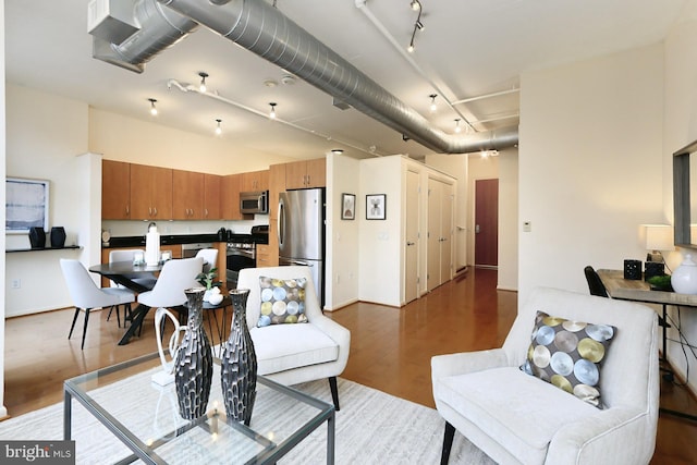 living room with wood-type flooring and rail lighting